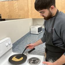 Student frying a roti