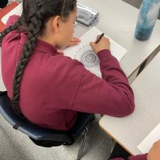 Student drawing a mandala